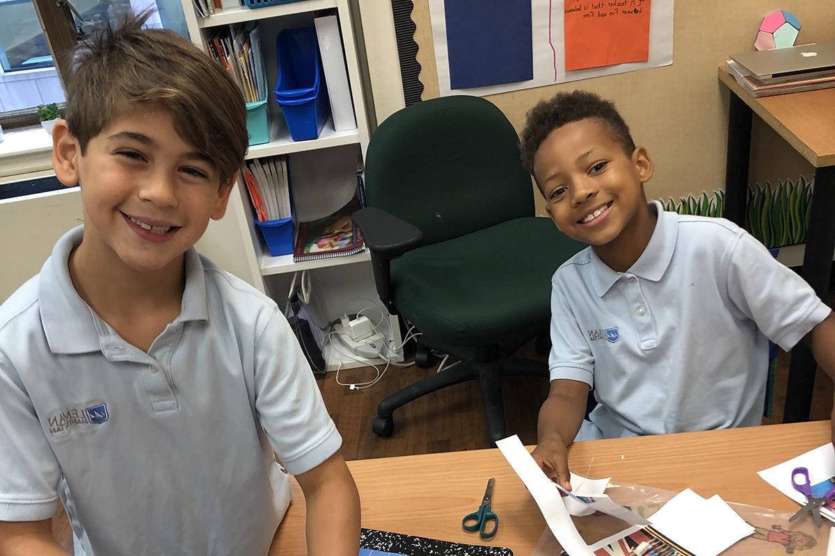 两个男孩坐在课桌前微笑着